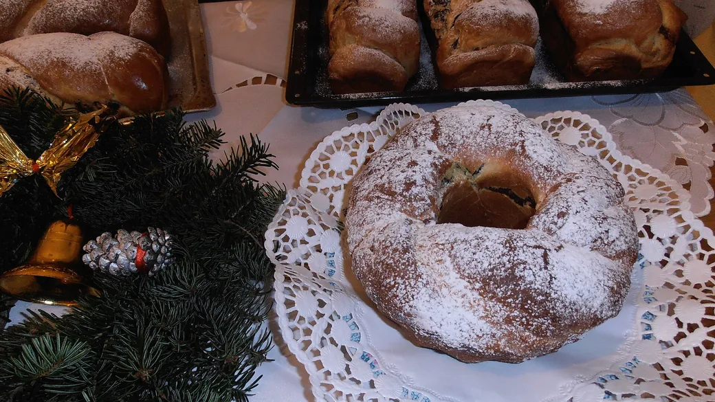 Cozonaci pudrați cu zahăr, lângă crenguțe de brad și ornamente de Crăciun