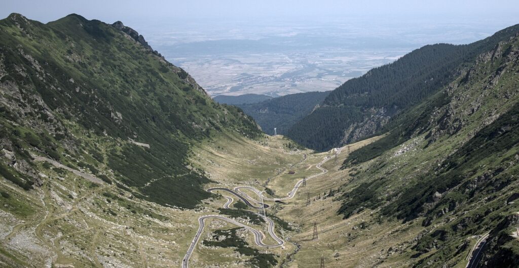 Serpentinele Transfăgărășanului coborând prin valea glaciară a Munților Făgăraș, spre câmpia Țării Făgărașului