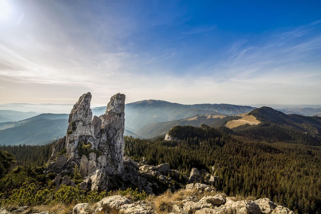 Pietrele Doamnei, colții calcaroși din masivul Rarău, cu crestele împădurite ale Bucovinei în fundal